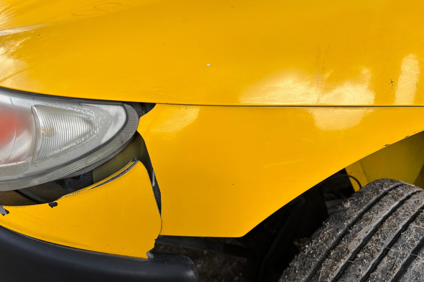 A dented front wing on a yellow car